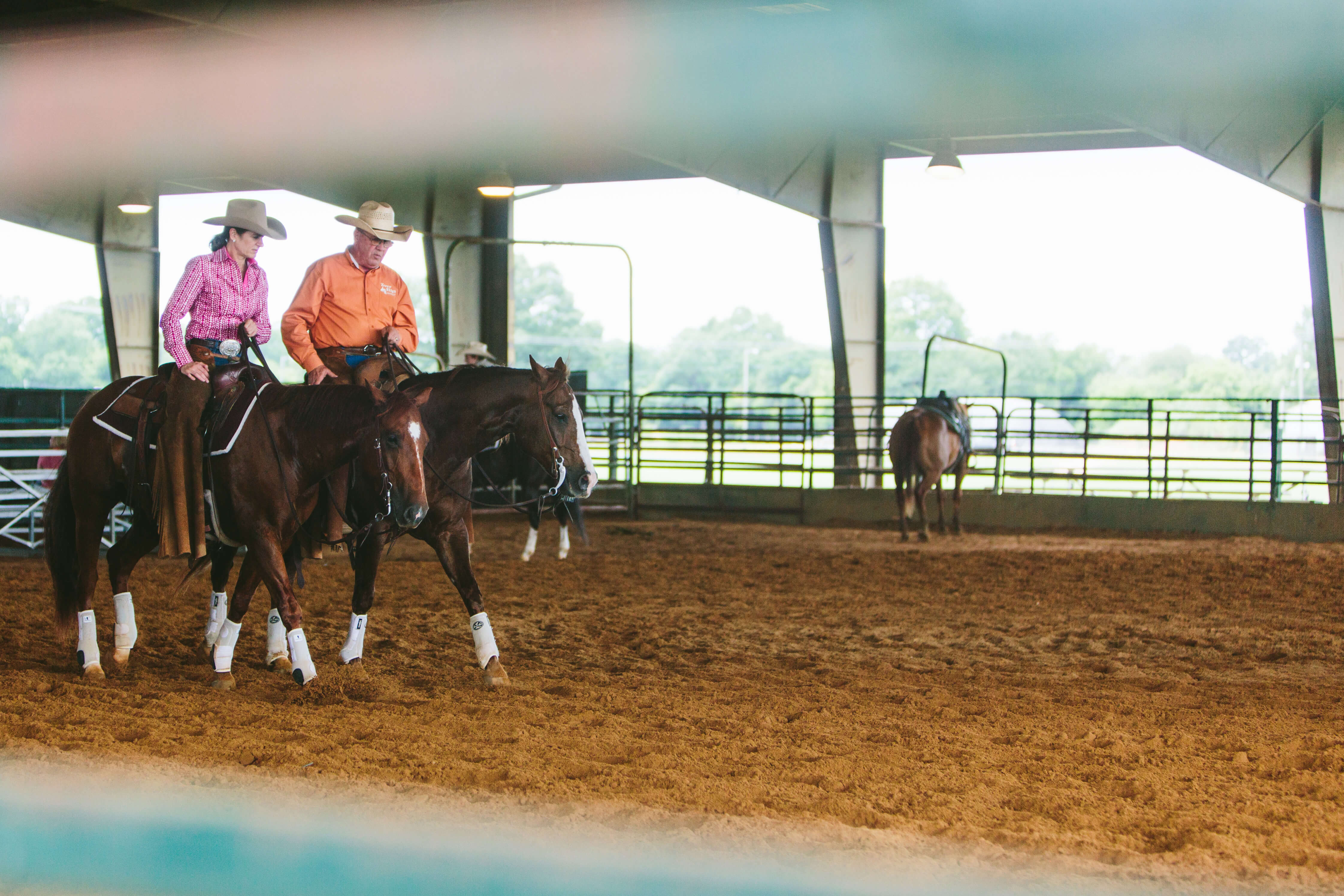 cowboy and cowgirl talking on horseback