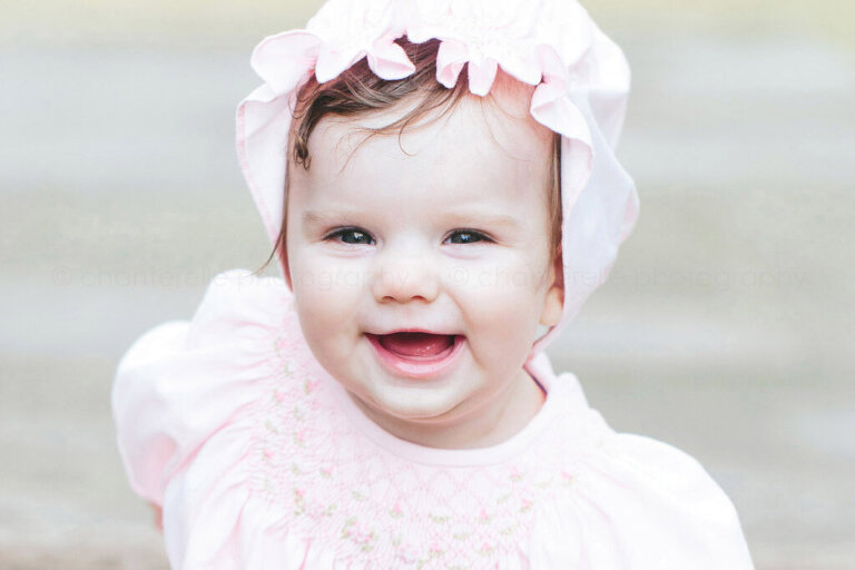 baby in pink bonnet smiling at blount cultural park
