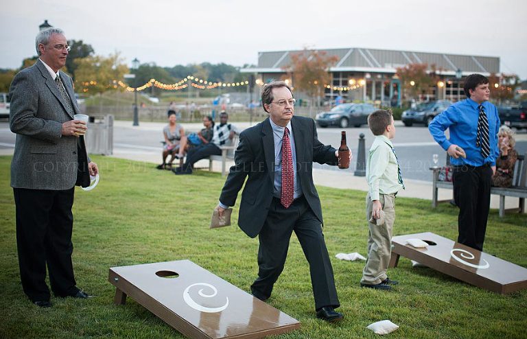 guests playing cornhole at a wedding reception at hampstead in alabama