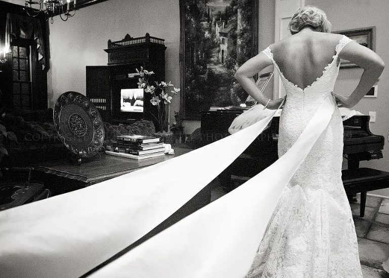 bride adding a long sash to her wedding gown at fountainview mansion