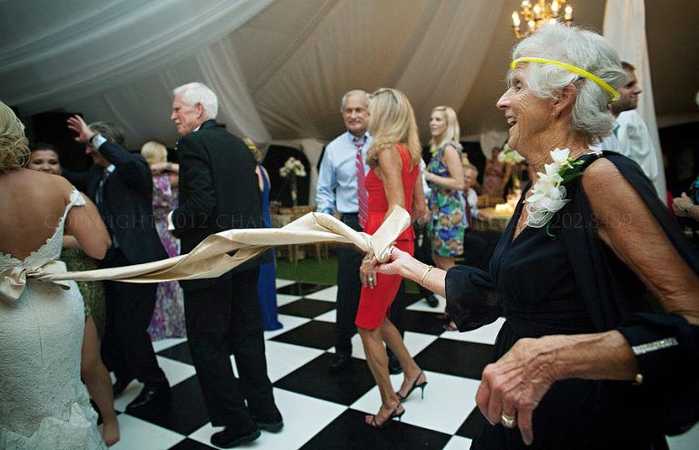 a grandmother plays with a bride's sash at a fountainview mansion wedding reception