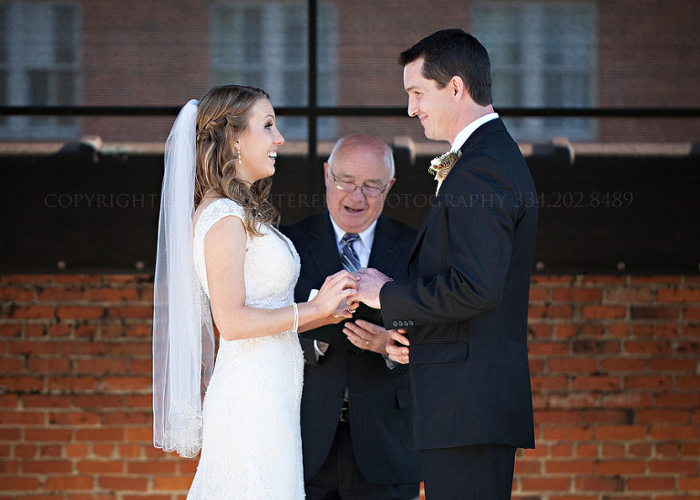 bride and groom exchanging rings on alley station rooftop
