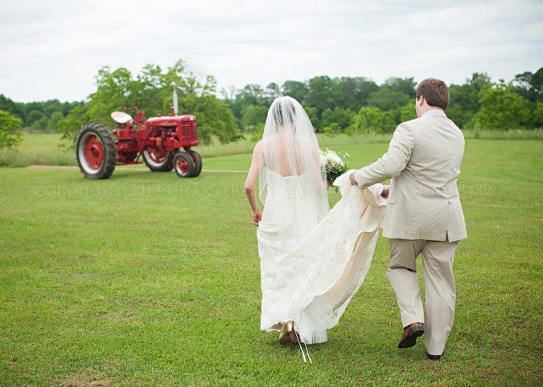 bride and groom with a red tractor at the oaks plantation