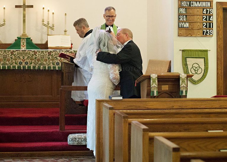 bride and groom kiss at st joseph of arimathea