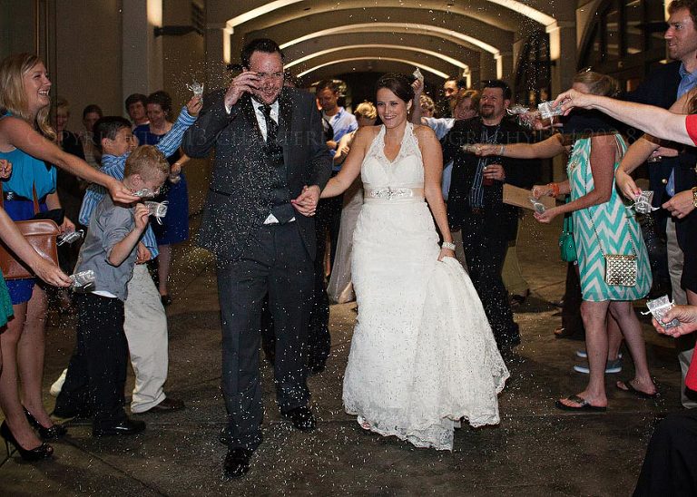 bride and groom exit alley station as guests throw lavender