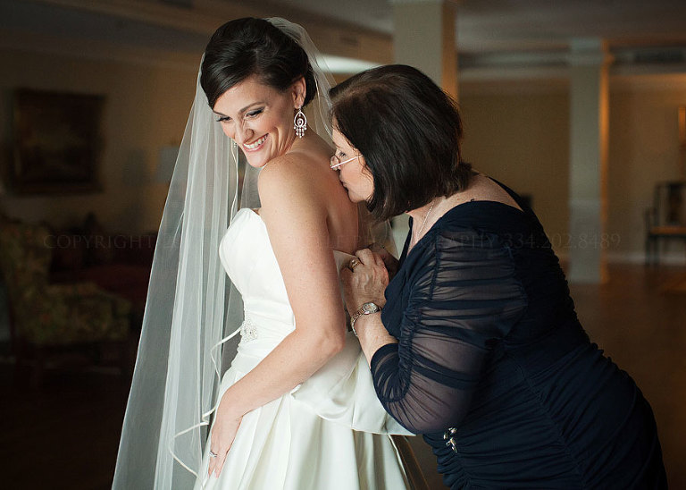 mother of the bride helping her daughter get dressed