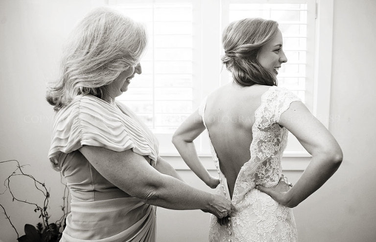 mother of the bride zipping up bride's liancarlo gown