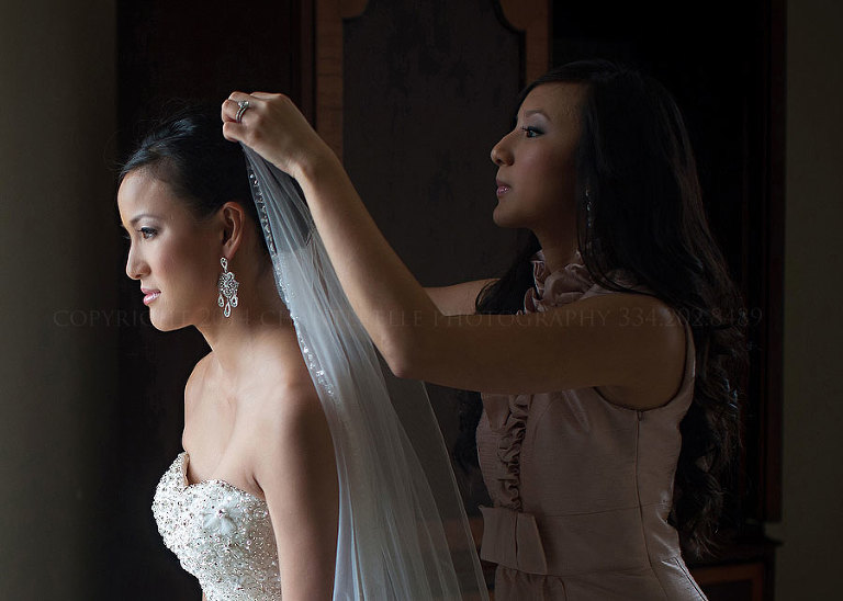 matron of honor putting veil on bride
