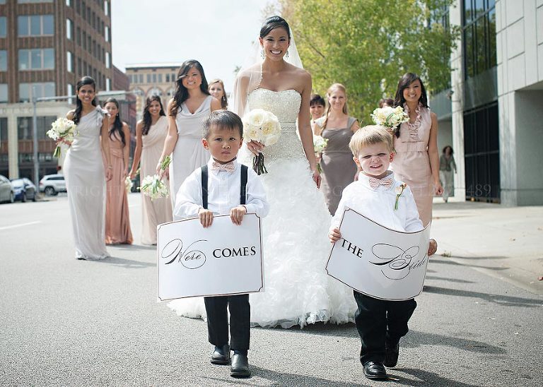 kids holding here comes the bride signs