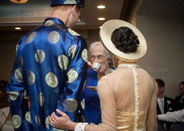 bride and groom offering tea to grandmother