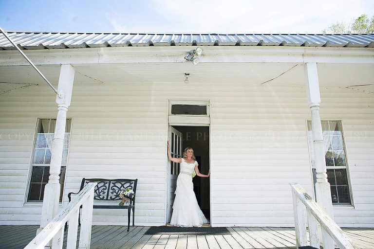 bride in doorway of white rustic building