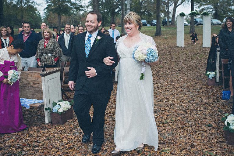 bride and brother walking down the aisle at outdoor wedding