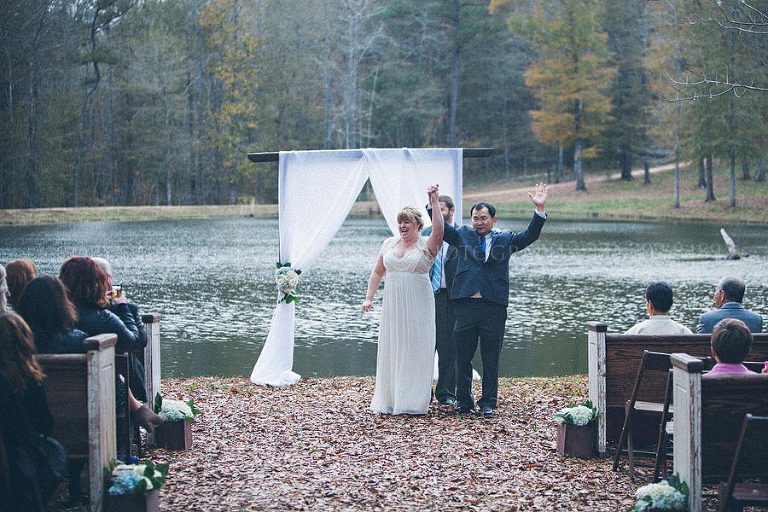 bride and groom celebrate at end of outdoor rustic wedding ceremony