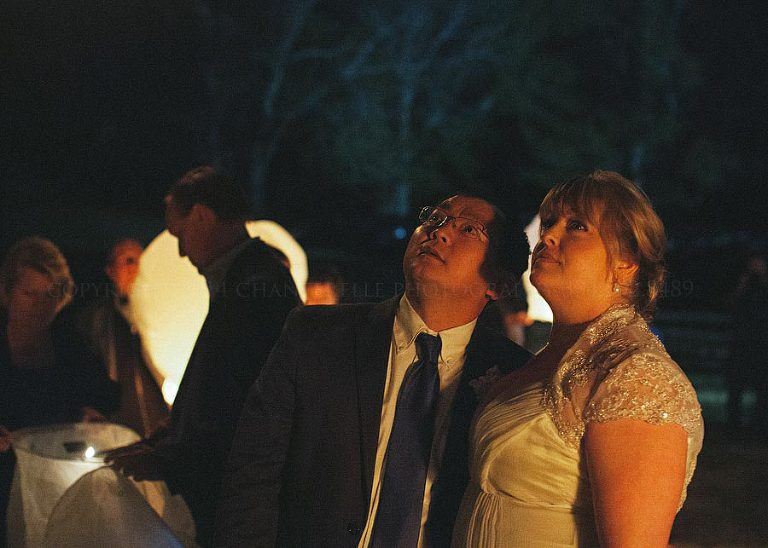 bride and groom watch wish lanterns in the sky