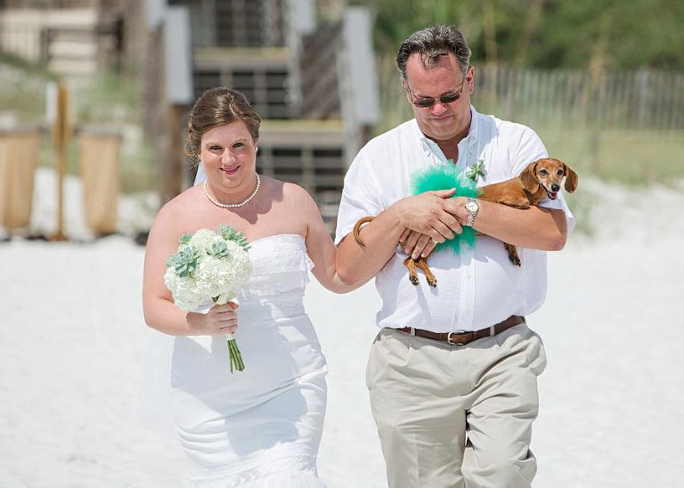 bride and her father and dog walk down the aisle in destin