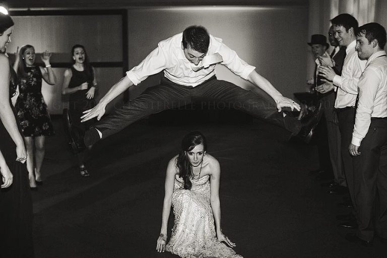 groom leapfrogging over bride at auburn wedding reception
