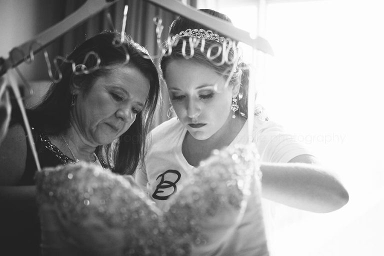 mother and bride getting ready to put on her allure bridals dress