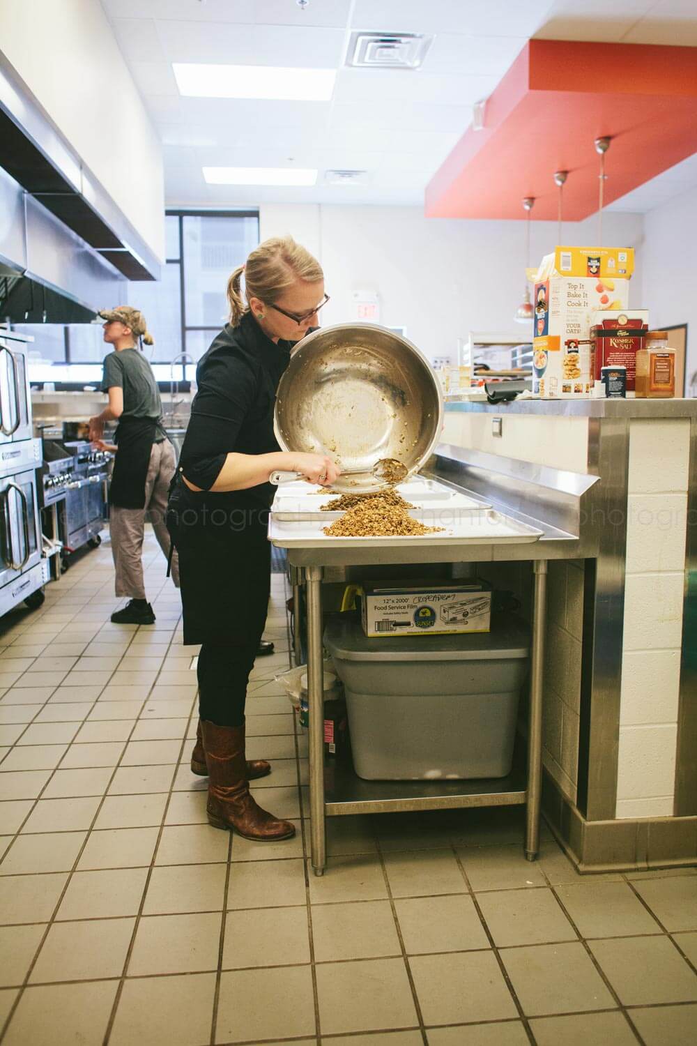 chef pouring granola onto sheet pans in nashville kitchen