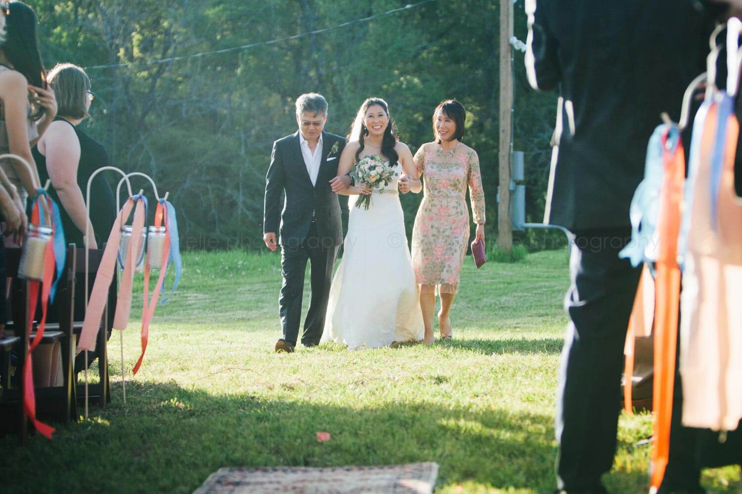 mom and dad walk bride down the aisle at alabama rustic wedding