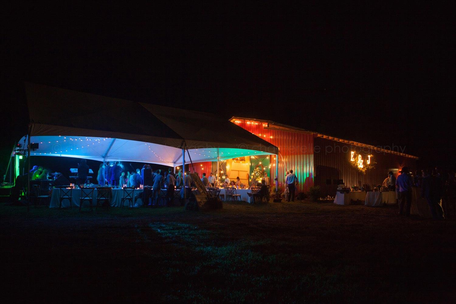 wedding reception tent lit with multicolored lights