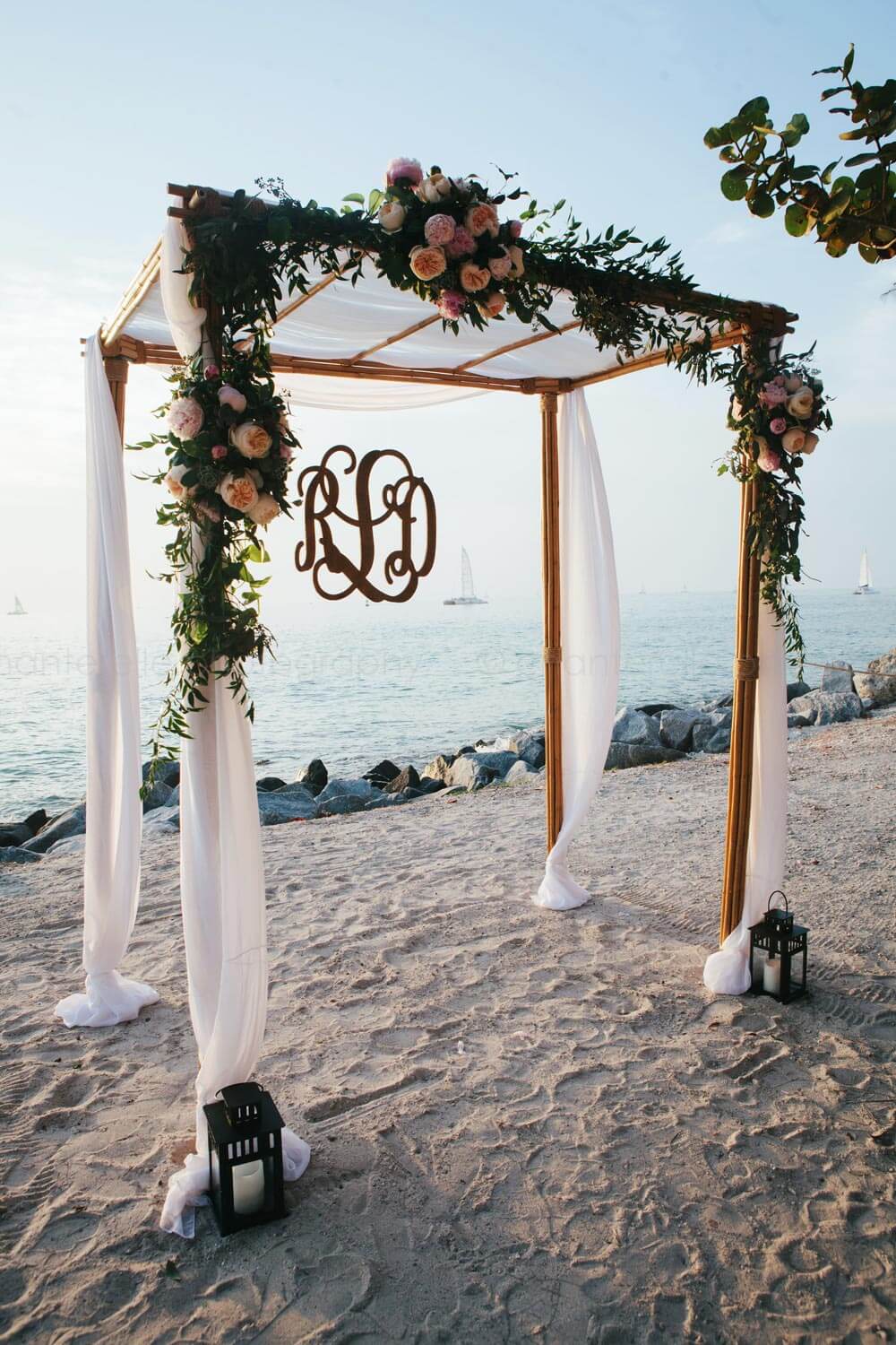 chuppah canopy with white draping and flowers at key west beach wedding ceremony