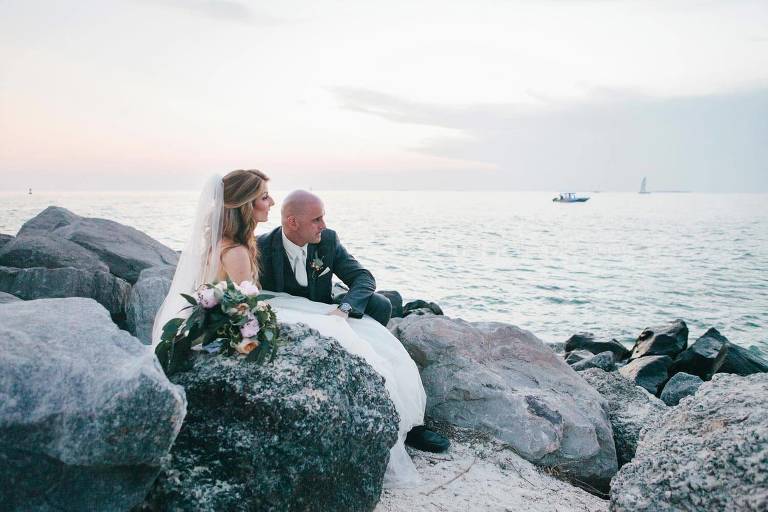 bride and groom on jetty with sun setting at fort zachary taylor beach wedding in key west