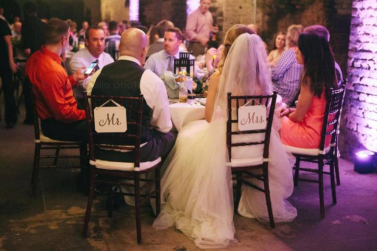 bride and groom signs on chairs at key west wedding reception