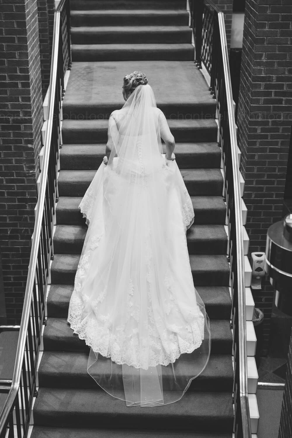 black and white of bride going up stairs