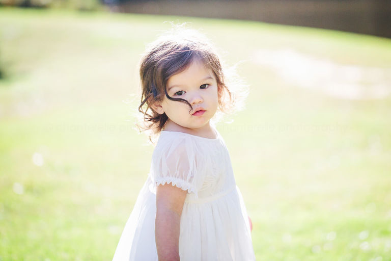 baby in white dress with windblown hair