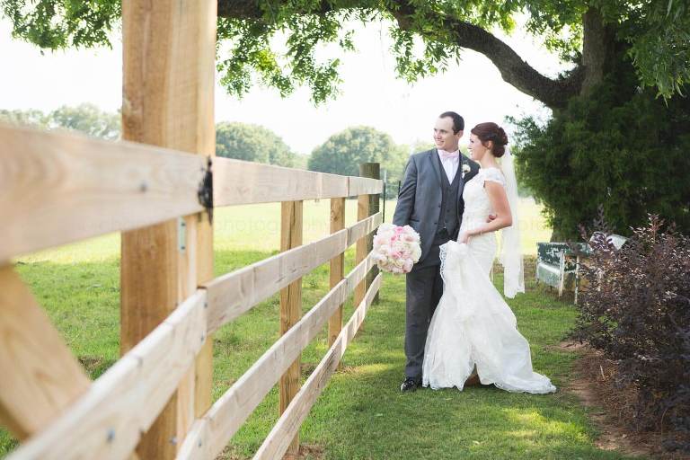 bride and groom together near rustic fence