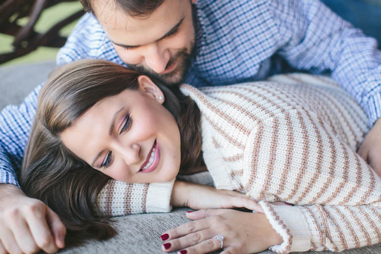 engaged couple snuggling on porch swing