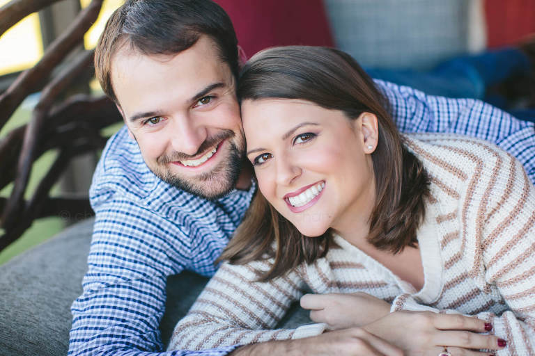 couple smiling while lying on porch swing