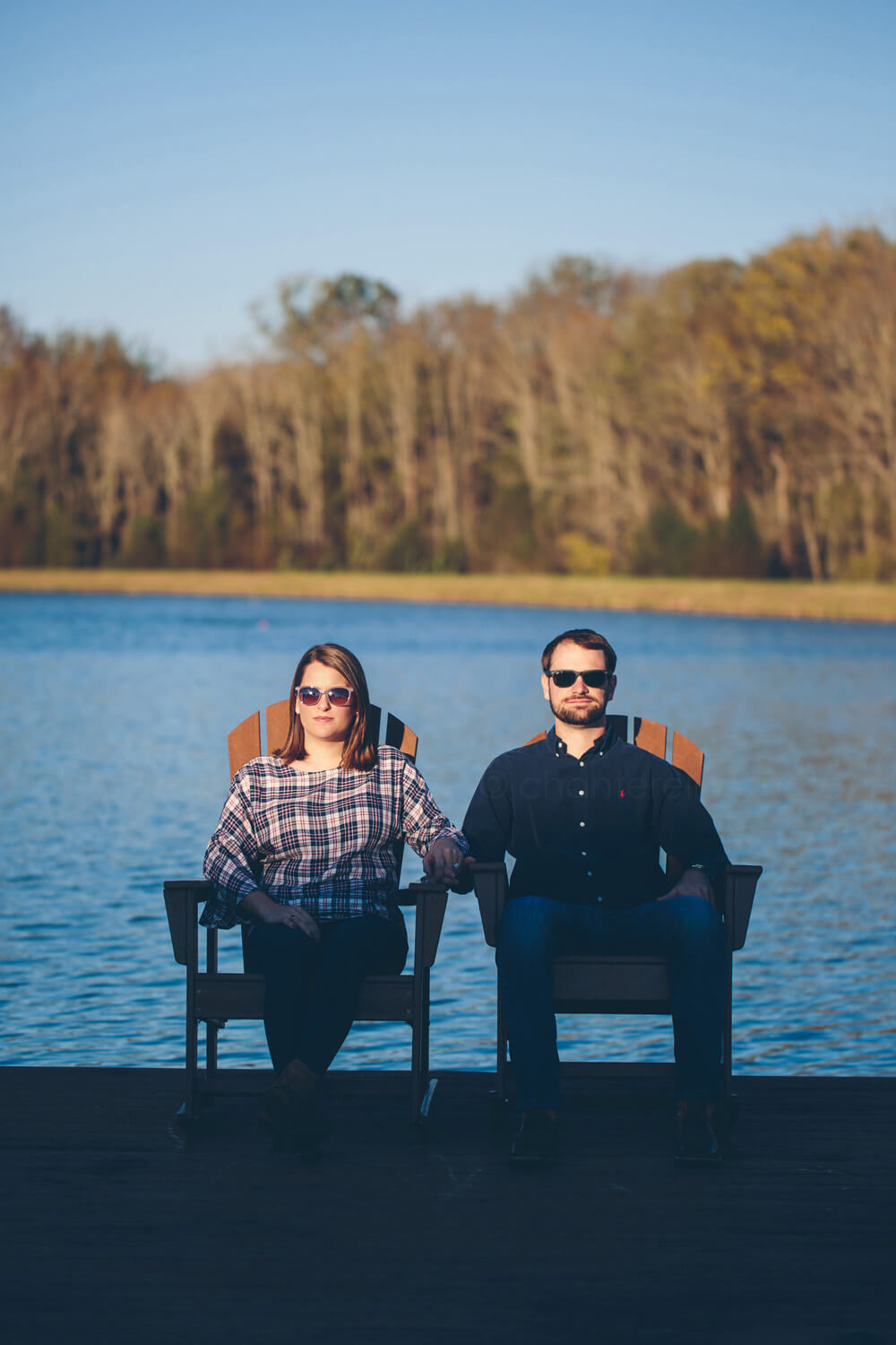 bride and groom to be wearing sunglasses in front of pond