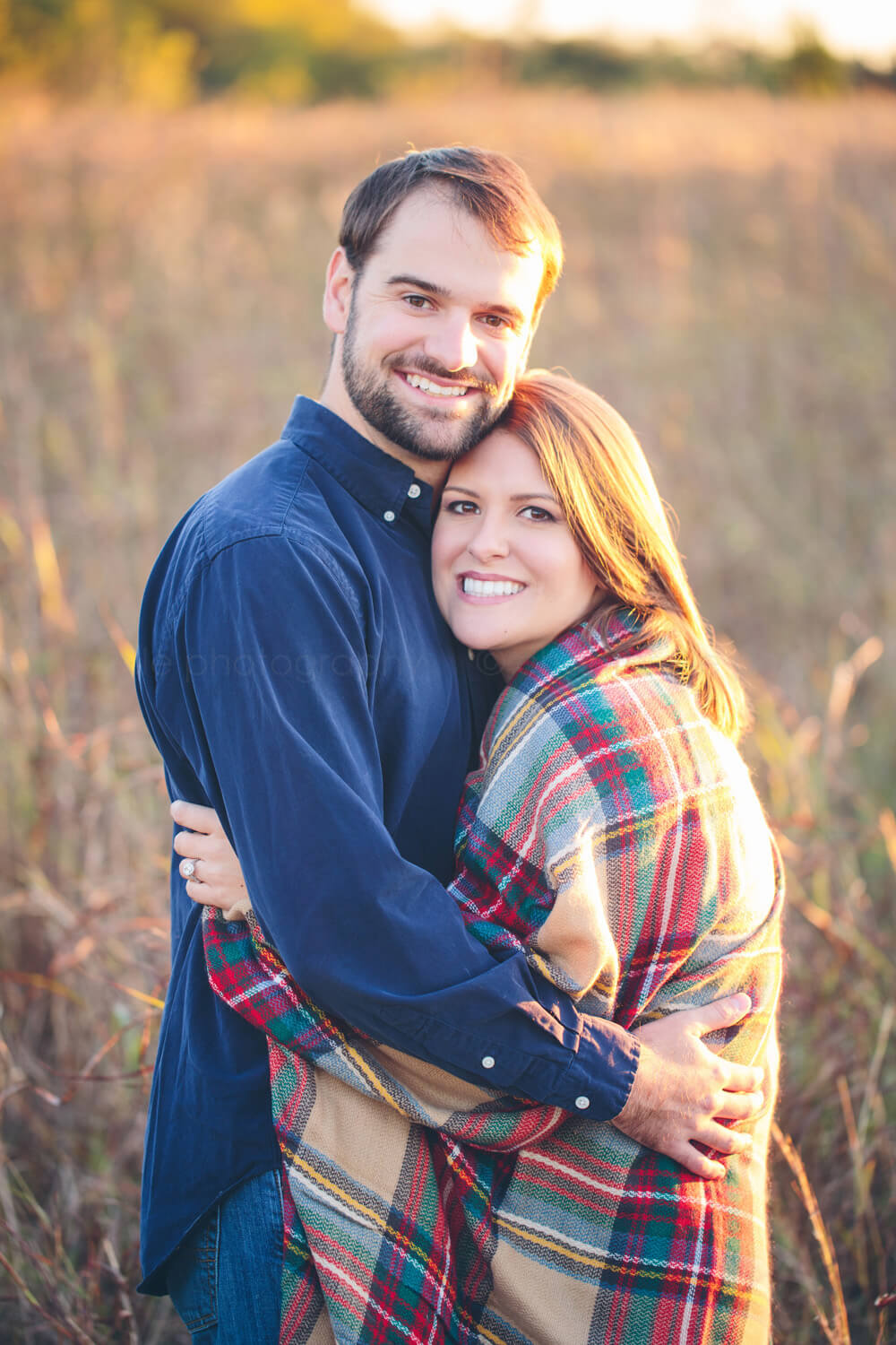 engaged couple hugging in field outside montgomery al