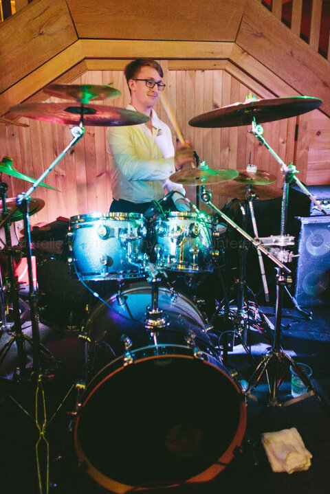 groom playing drums during canyon kitchen wedding reception