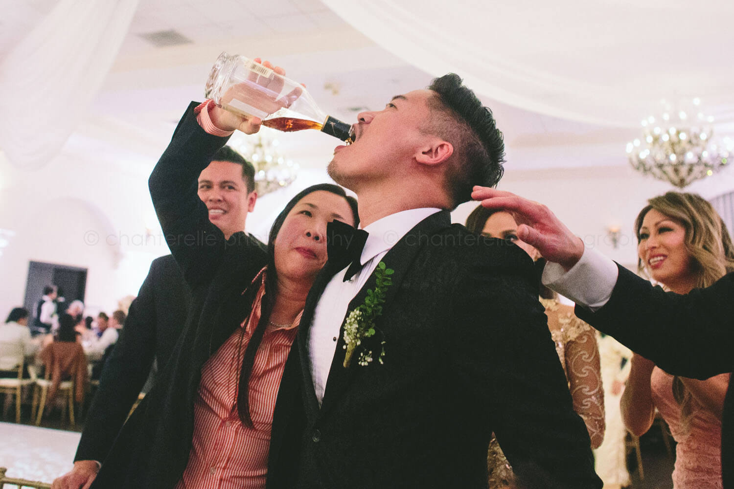 groom drinking hennessy at the villa wedding reception