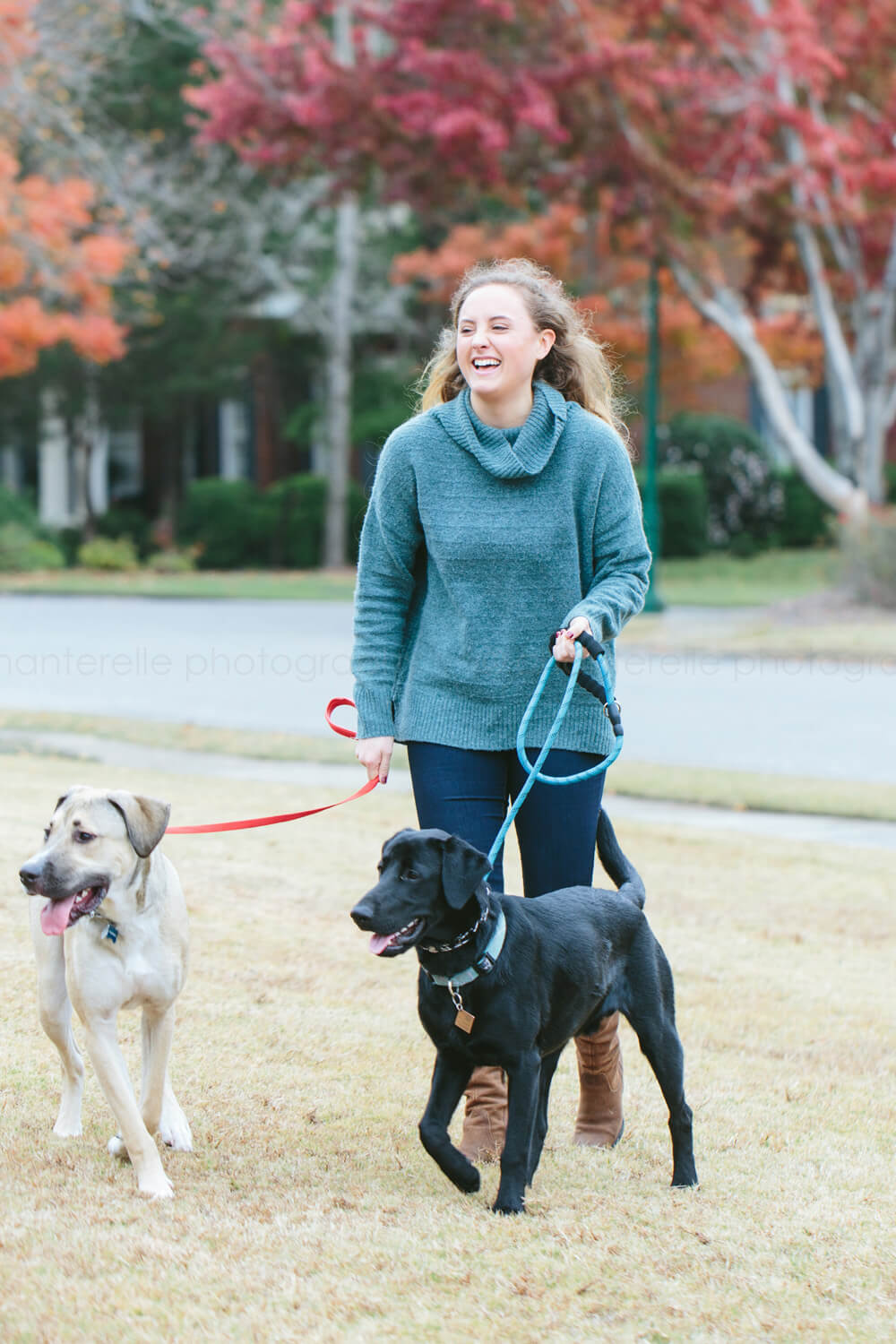 woman laughing while walking dogs