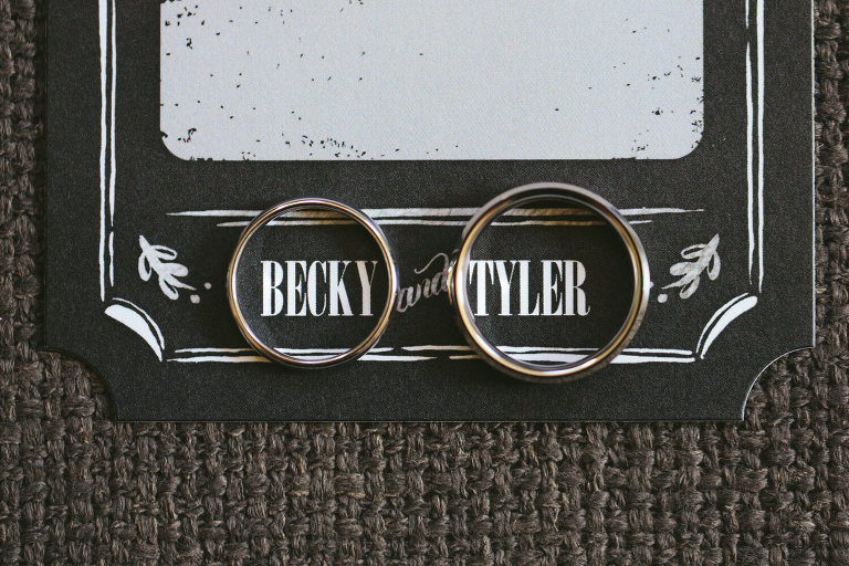 rings on black and white wedding invitation