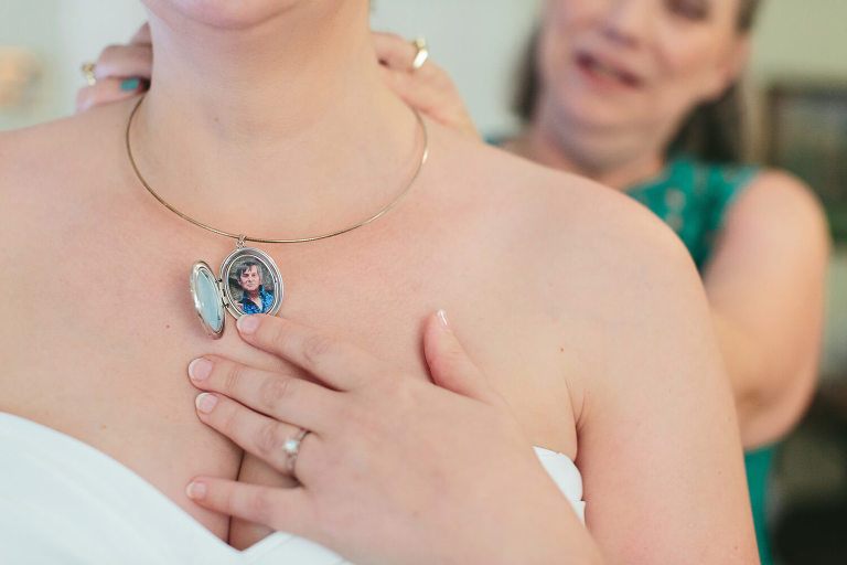 bride wearing locket with late father pictured