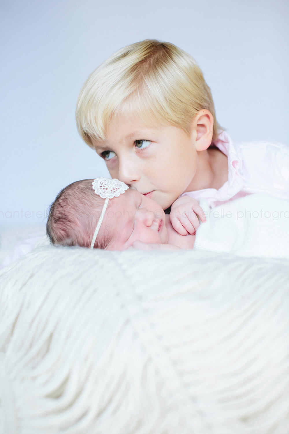big brother kissing newborn sister