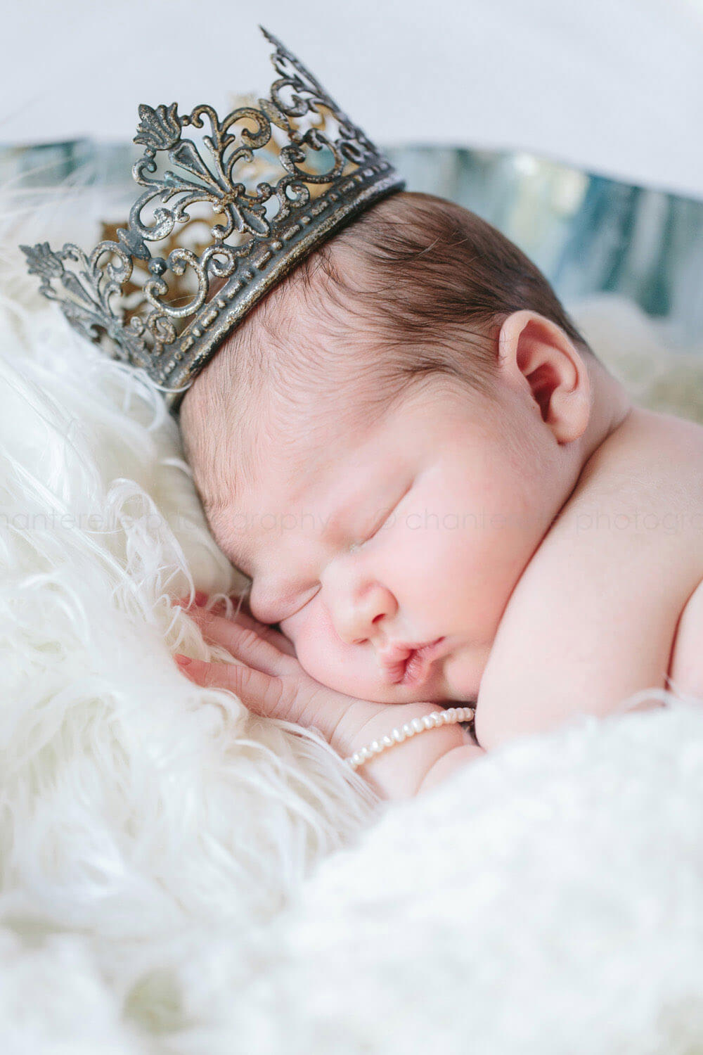 newborn sleeping wearing crown