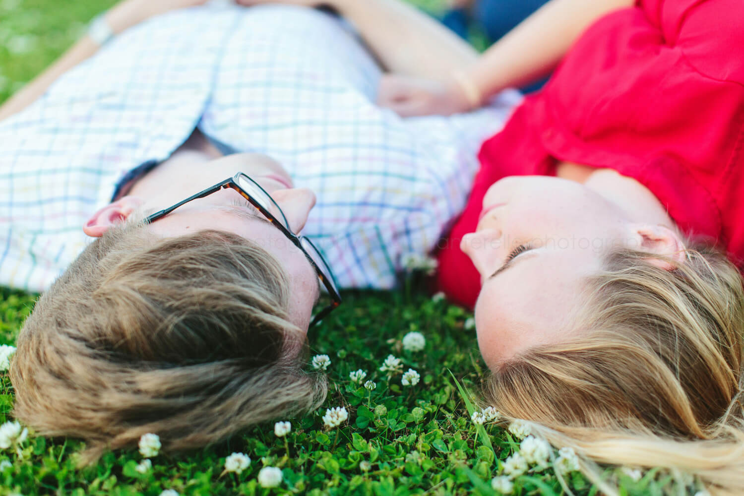 engaged couple lying in field