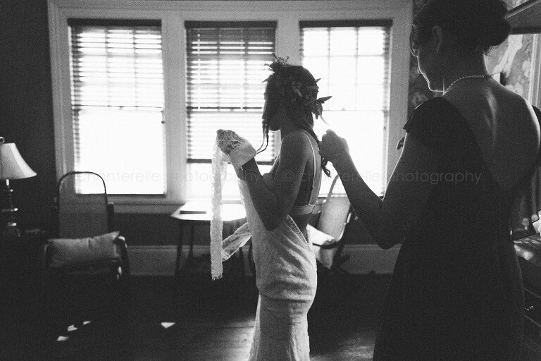black and white photo of bride getting dressed