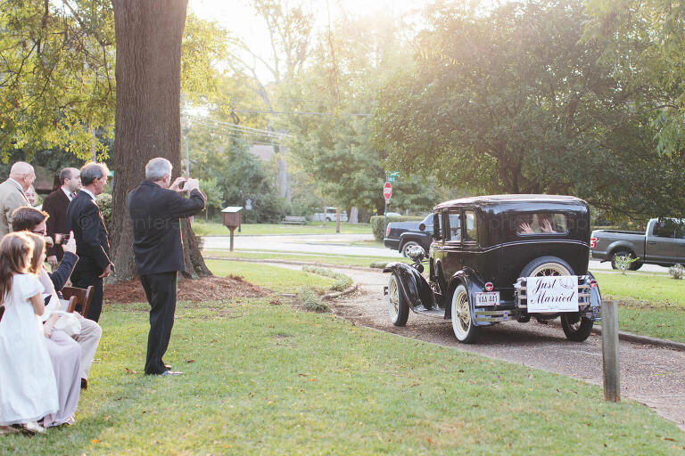 bride and groom leaving ceremony in vintage car
