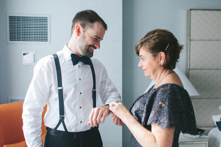 groom laughing with his mom while getting ready for atlanta wedding