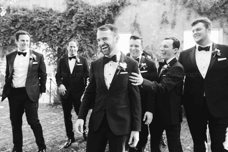 groom and groomsmen laughing in summerour courtyard