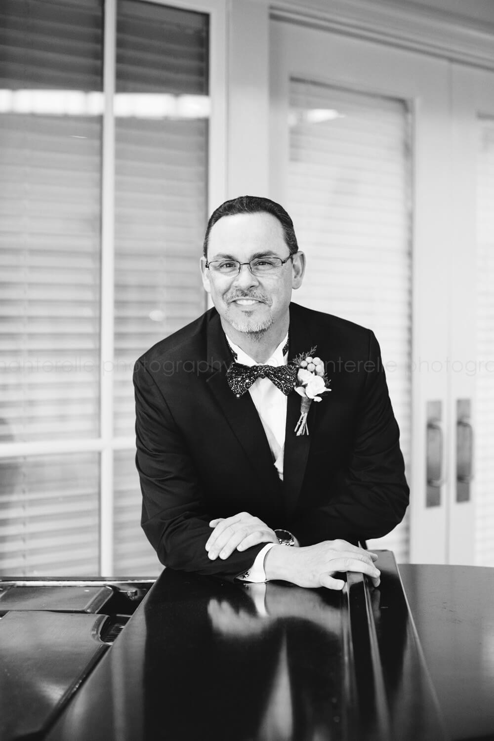 black and white groom photo with piano