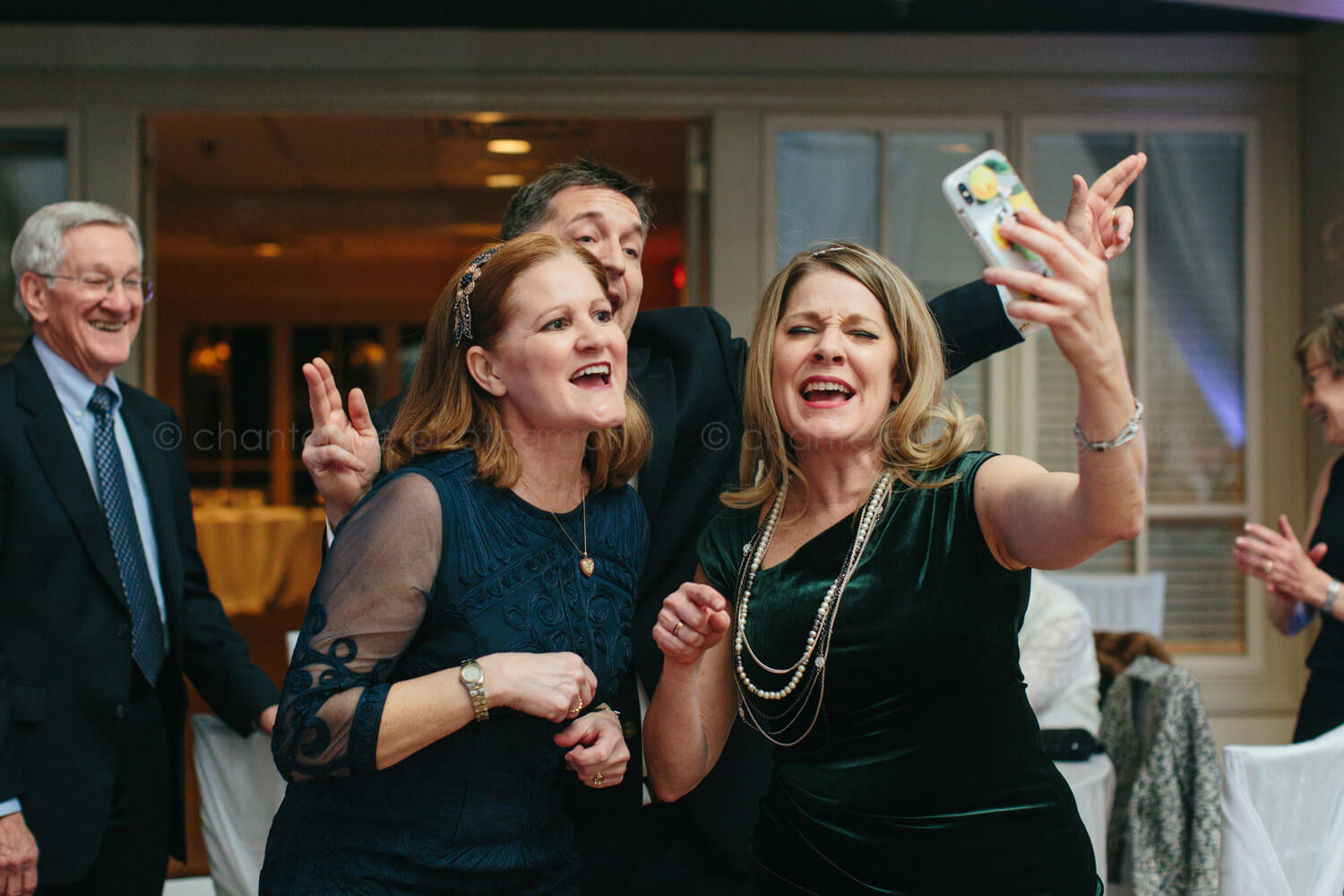 guests dancing while facetiming at wedding reception