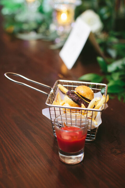 slider and fries in an individual basket with a shot glass of ketchup